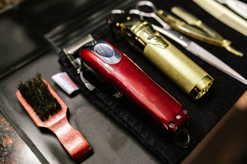 pexels-photo-7697208 Close-up of professional barber tools including clippers and scissors arranged neatly for a haircut.